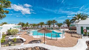 Een buitenzwembad, parasols voor strand/zwembad