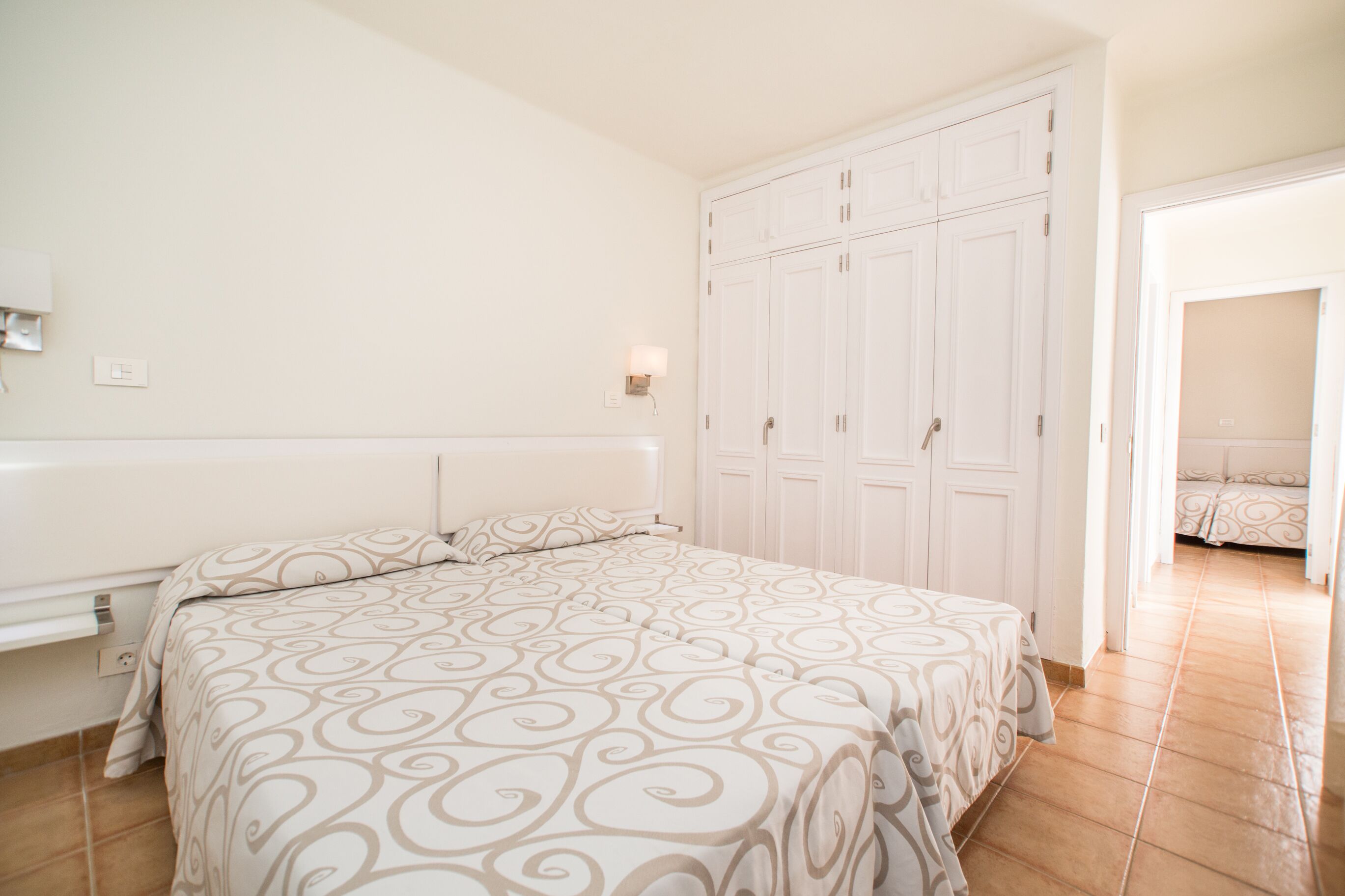 A bedroom with a bed, a wardrobe, and a nightstand.