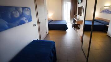Une chambre d’hôtel avec deux lits simples, un bureau avec une chaise, une télévision et un tableau au mur.