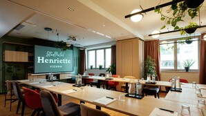 A conference room with a long table, chairs, and a projection screen displaying 'Stadthotel Henriette Vienna'. - Henriette Stadthotel Vienna (Vienna)