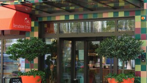 A restaurant named 'Henriette' with a colorful checkered facade and large potted plants at the entrance. - Henriette Stadthotel Vienna (Vienna)