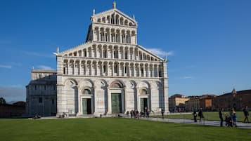 Un grand bâtiment historique, doté d’une entrée centrale imposante et de nombreuses arcades.