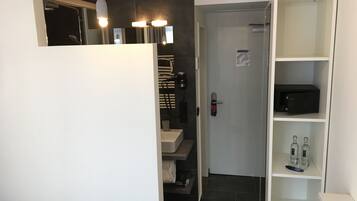 A modern bathroom with a shower, a toilet, a sink, and a built-in cabinet with toiletries.