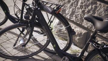 Una bicicleta estacionada contra una pared de piedra, con un portabotellas y un asiento.