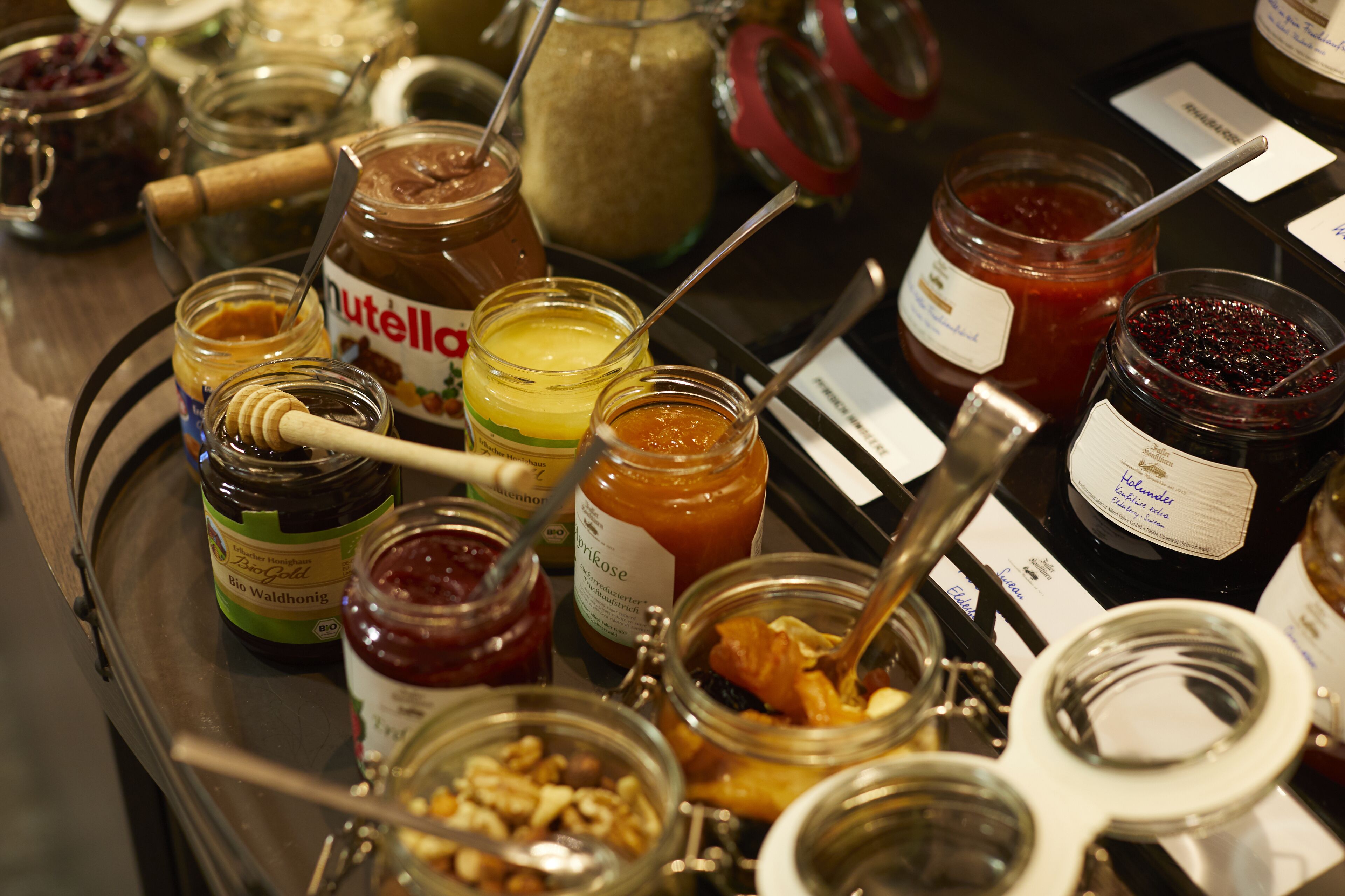 A variety of jars of spreads and condiments on a tray.