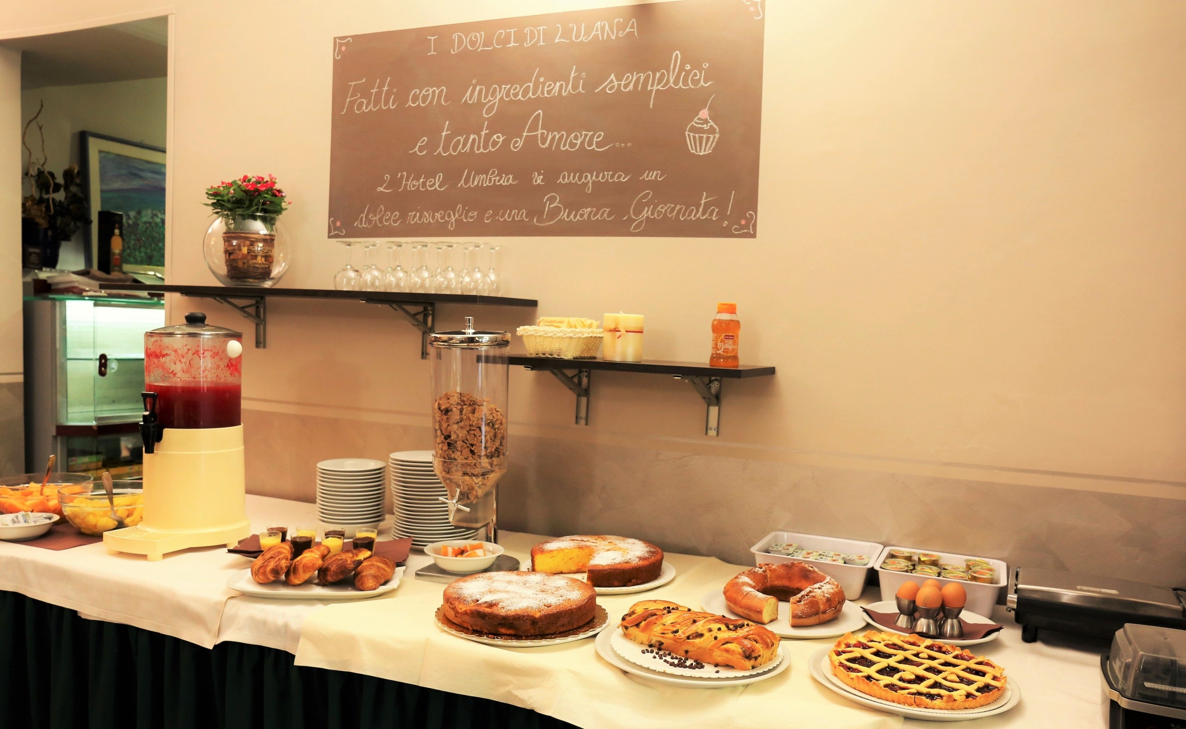 Une table de buffet proposant une variété de produits de boulangerie et de boissons.