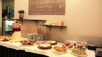 Une table de buffet proposant une variété de produits de boulangerie et de boissons.
