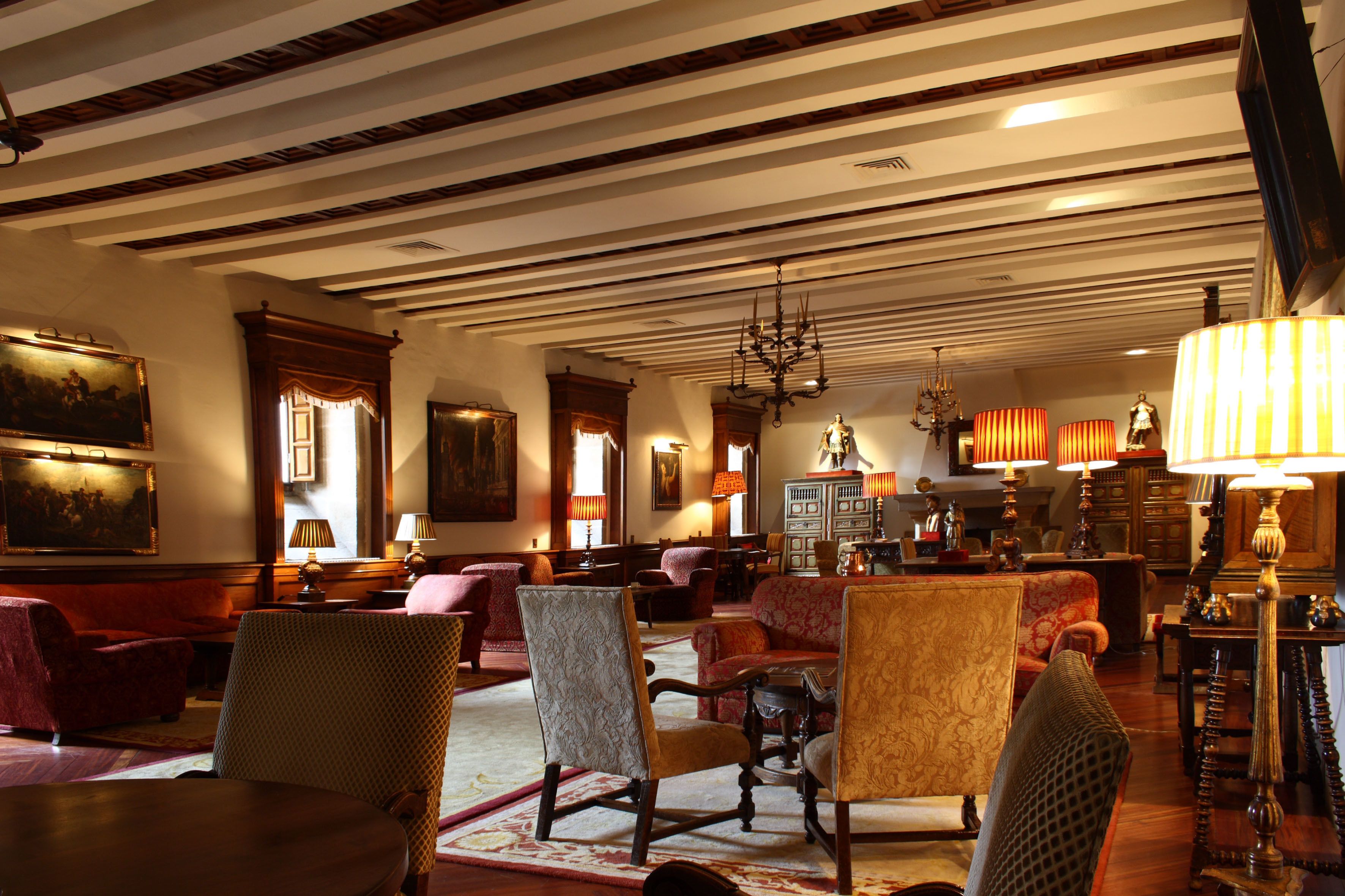 A spacious living room with multiple seating areas, a chandelier, and a fireplace.