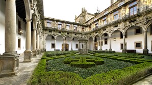 A courtyard with a central garden, surrounded by classical architecture with columns and arches. - Parador de Santiago de Compostela (Santiago de Compostela)