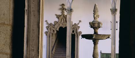 An ornate stone archway with a central fountain.