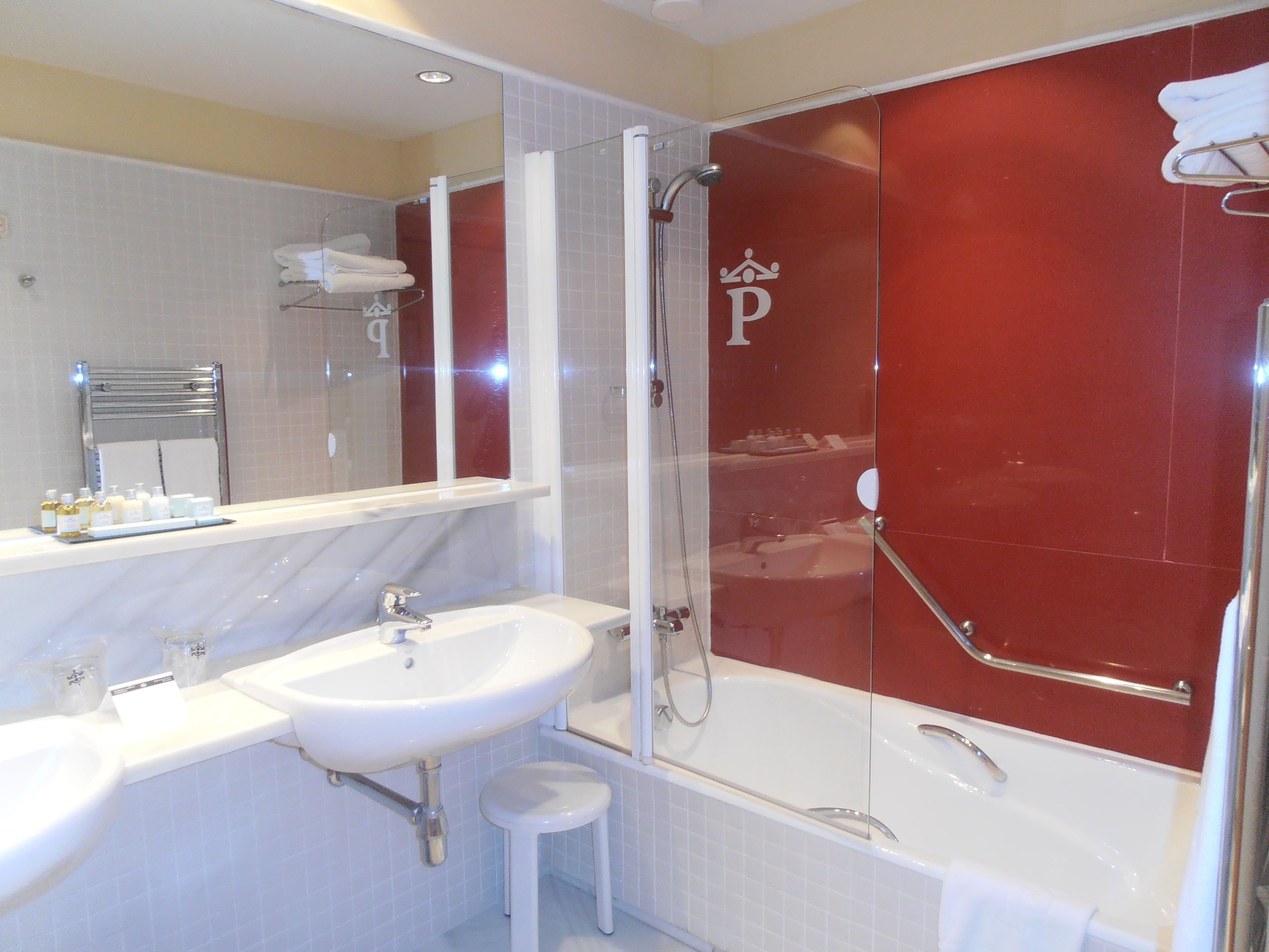 Une salle de bain moderne avec un lavabo blanc, un miroir et une douche à parois de verre.