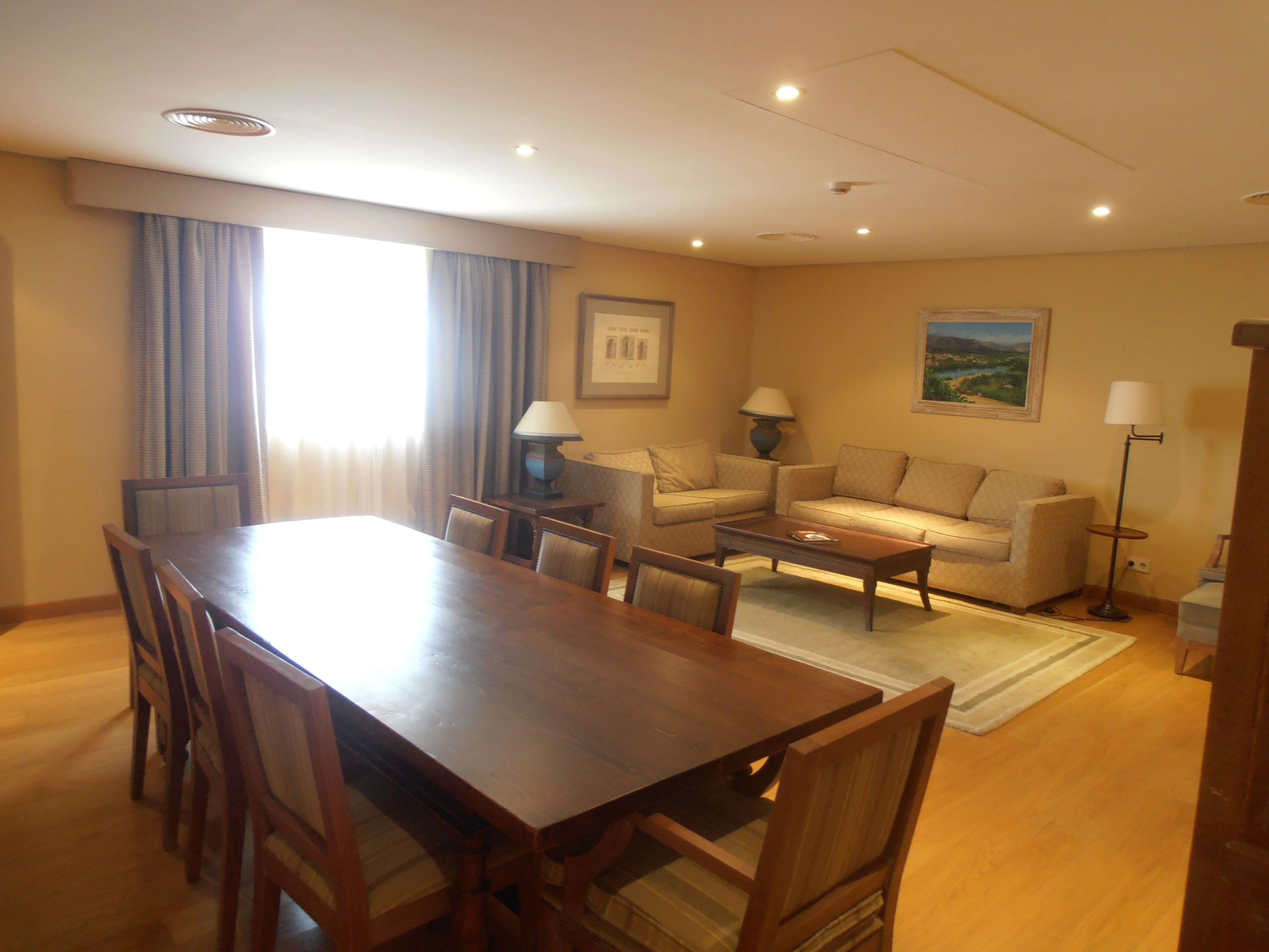 Un salón amplio con una mesa de comedor de madera, sofás cómodos y una mesa auxiliar.