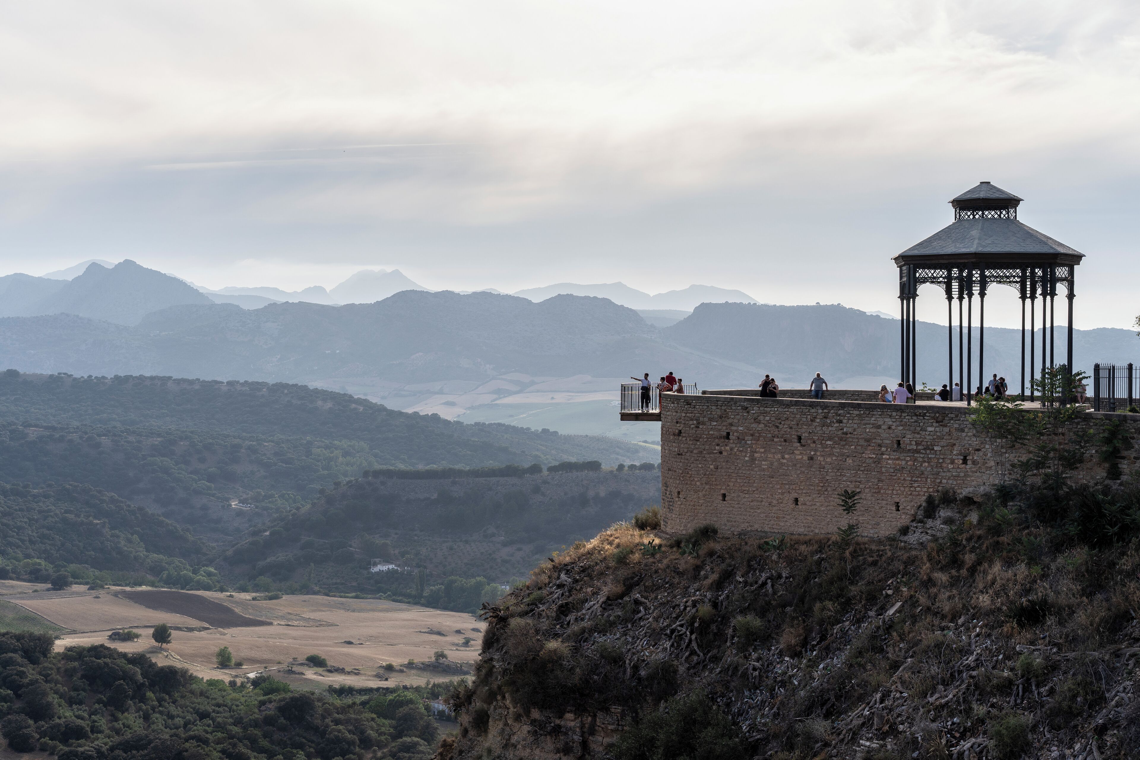 Una torre de piedra con un pabellón en la cima, con vistas a un valle y montañas al fondo.