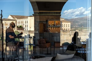 A restaurant with outdoor seating, a bar, and a view of the cityscape. - Parador de Ronda (Ronda)
