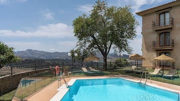 Alberca al aire libre por temporada y sombrillas en la alberca