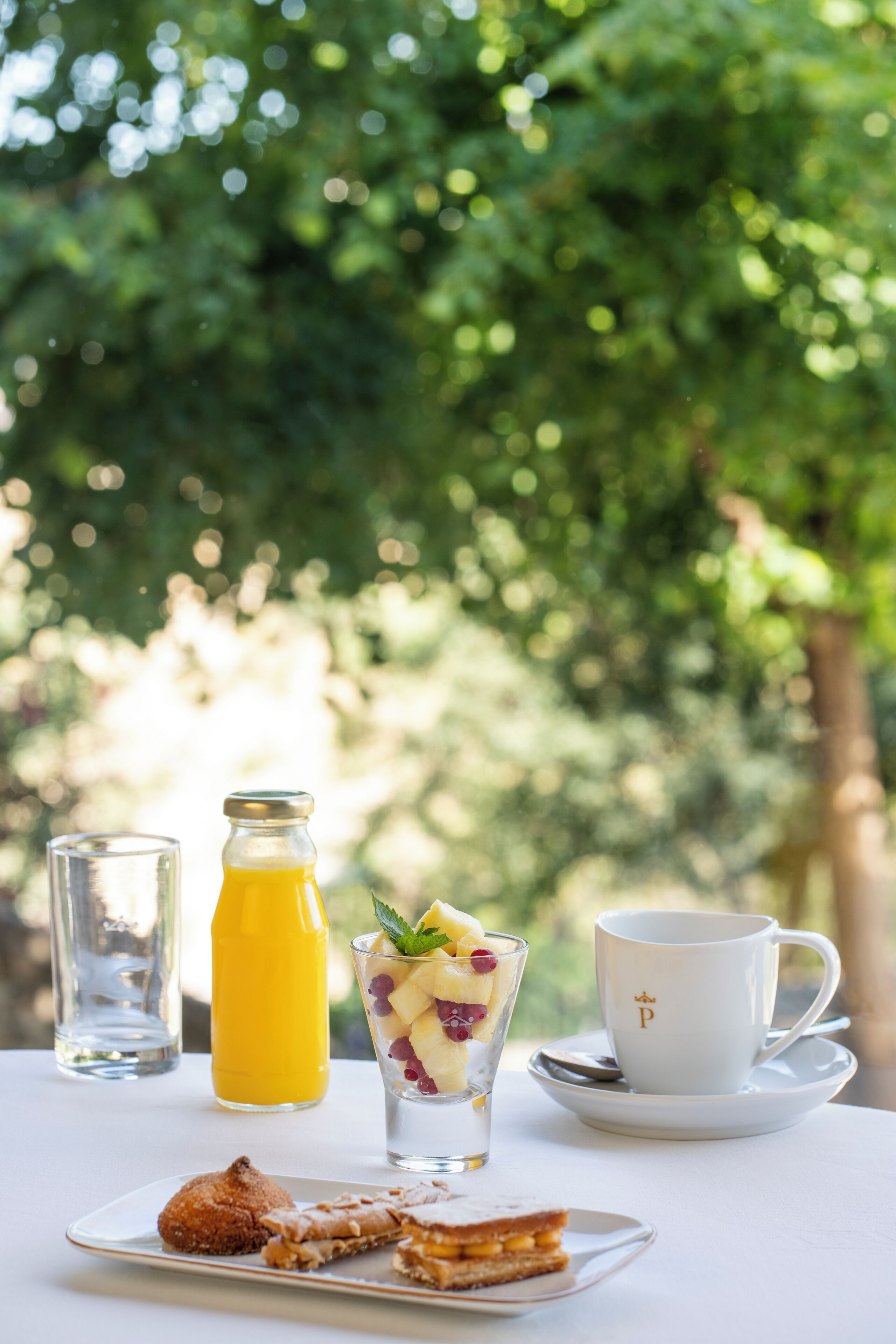 A breakfast setting with a glass of orange juice, a cup of coffee, and a plate of food.