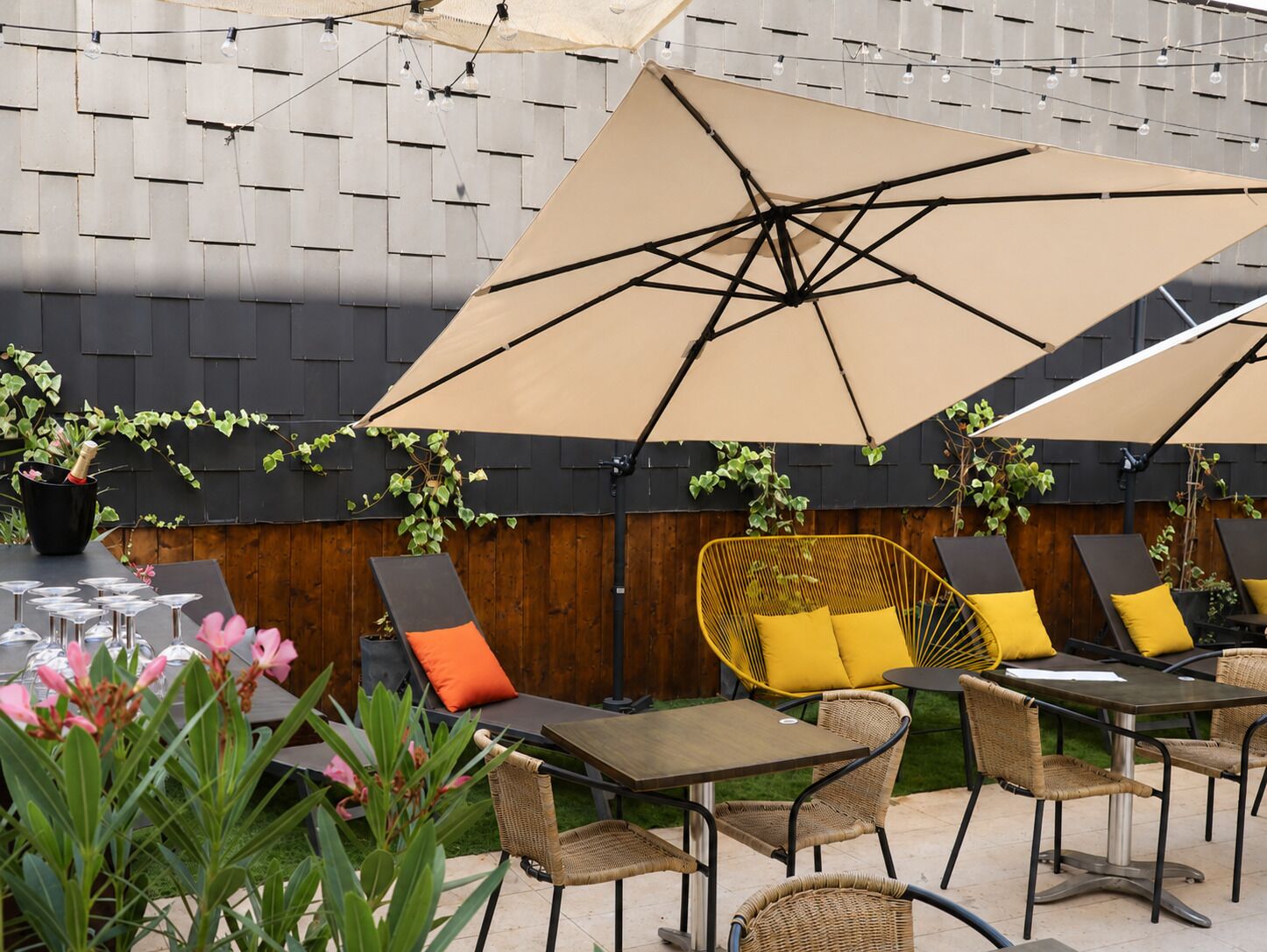 An outdoor patio area with tables, chairs, and umbrellas.