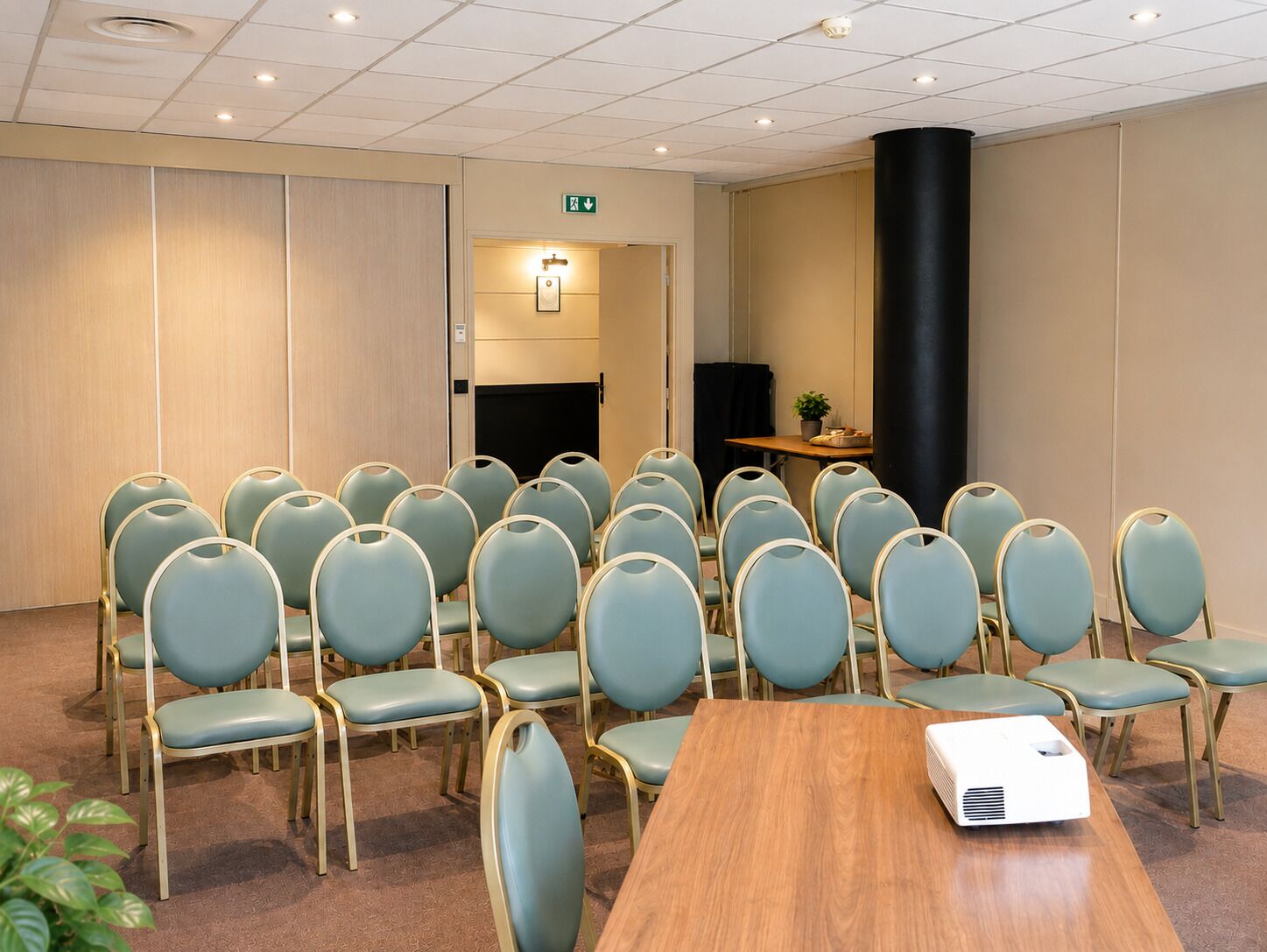A conference room with rows of chairs, a projector, and a table.