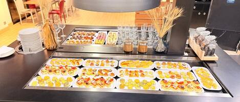 Un bufé con diversos alimentos y cristalería.