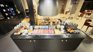 A buffet setup with various food items and condiments. - Kyriad Blois Sud-Vineuil (Vineuil)