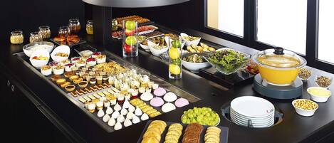 Una mesa de buffet con diferentes alimentos y una lámpara grande arriba.