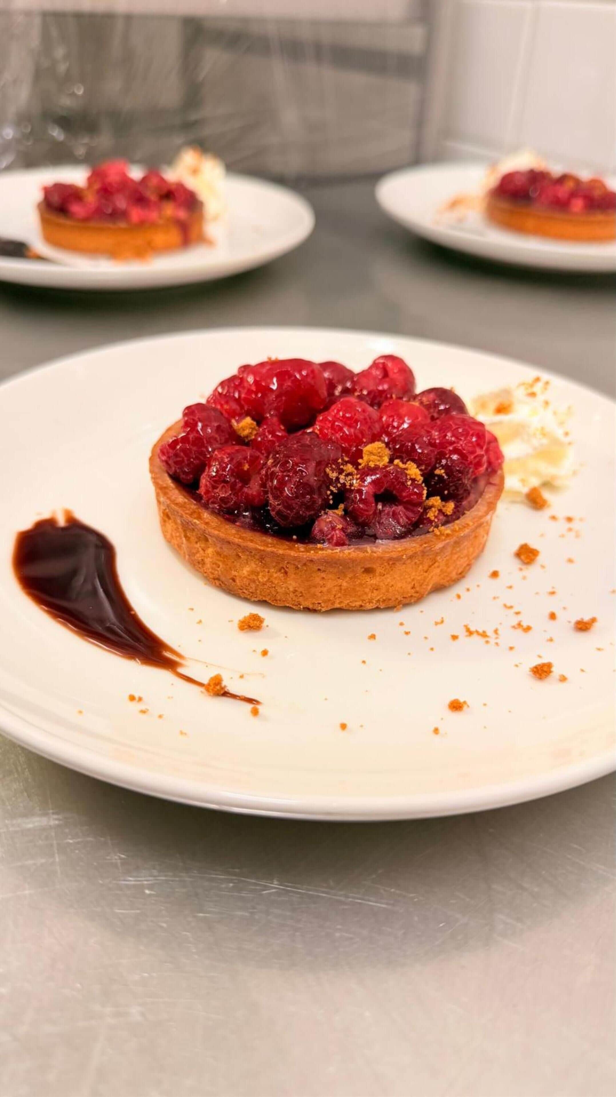 A dessert with raspberries on a plate.