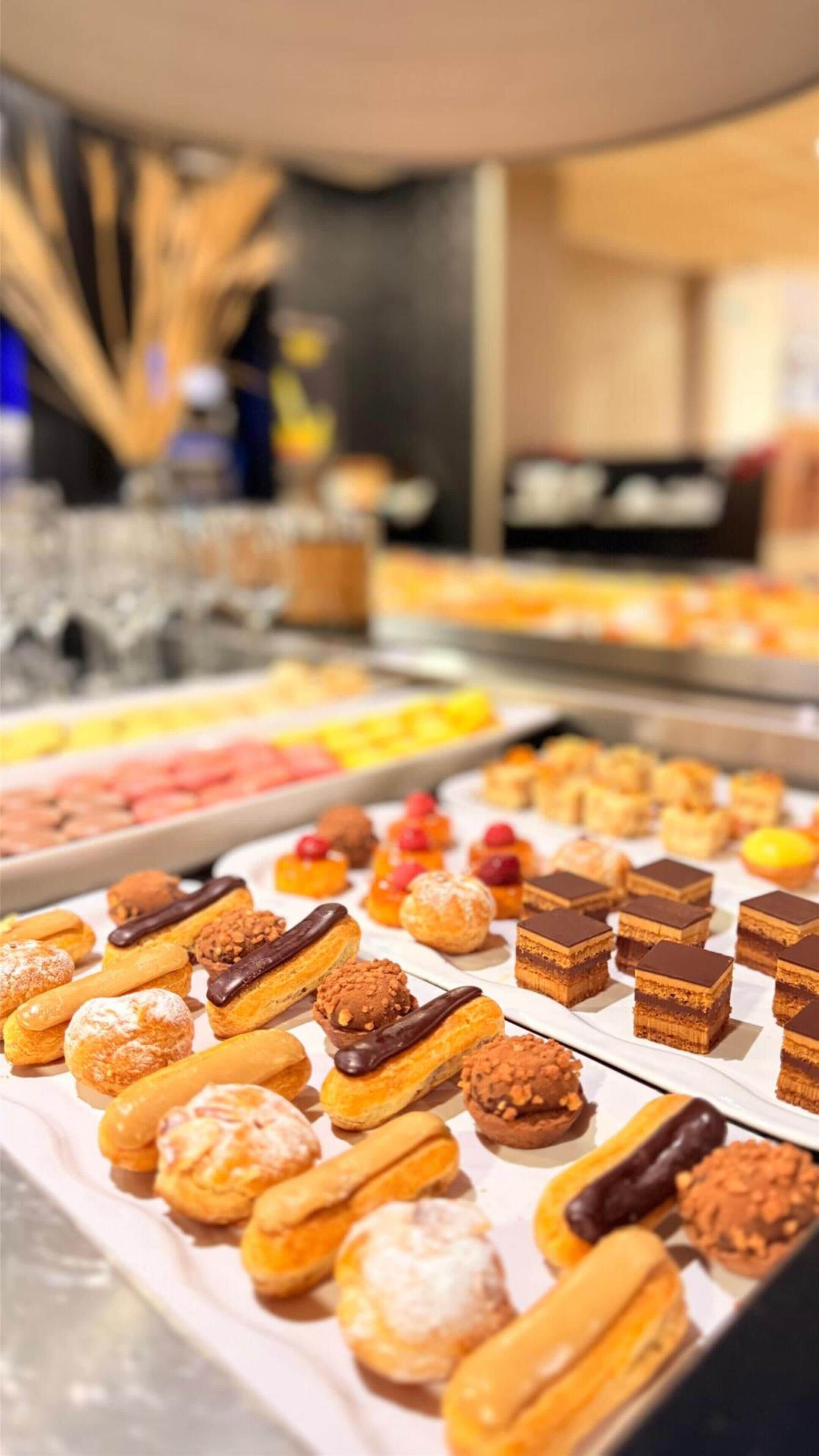 Una selección de pasteles y postres expuestos en bandejas.