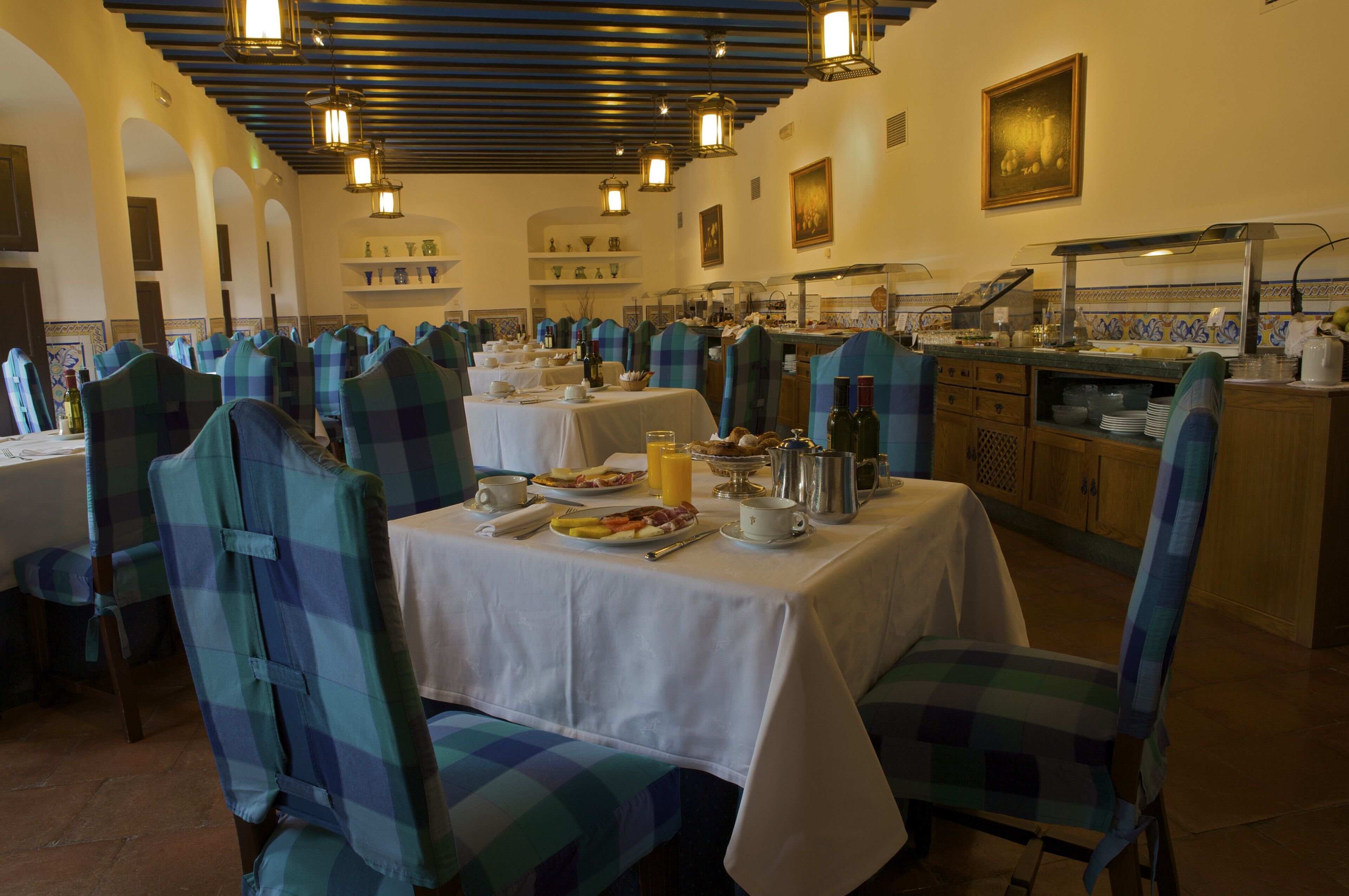 A restaurant with checkered chairs, tables set with plates, glasses, and bottles.
