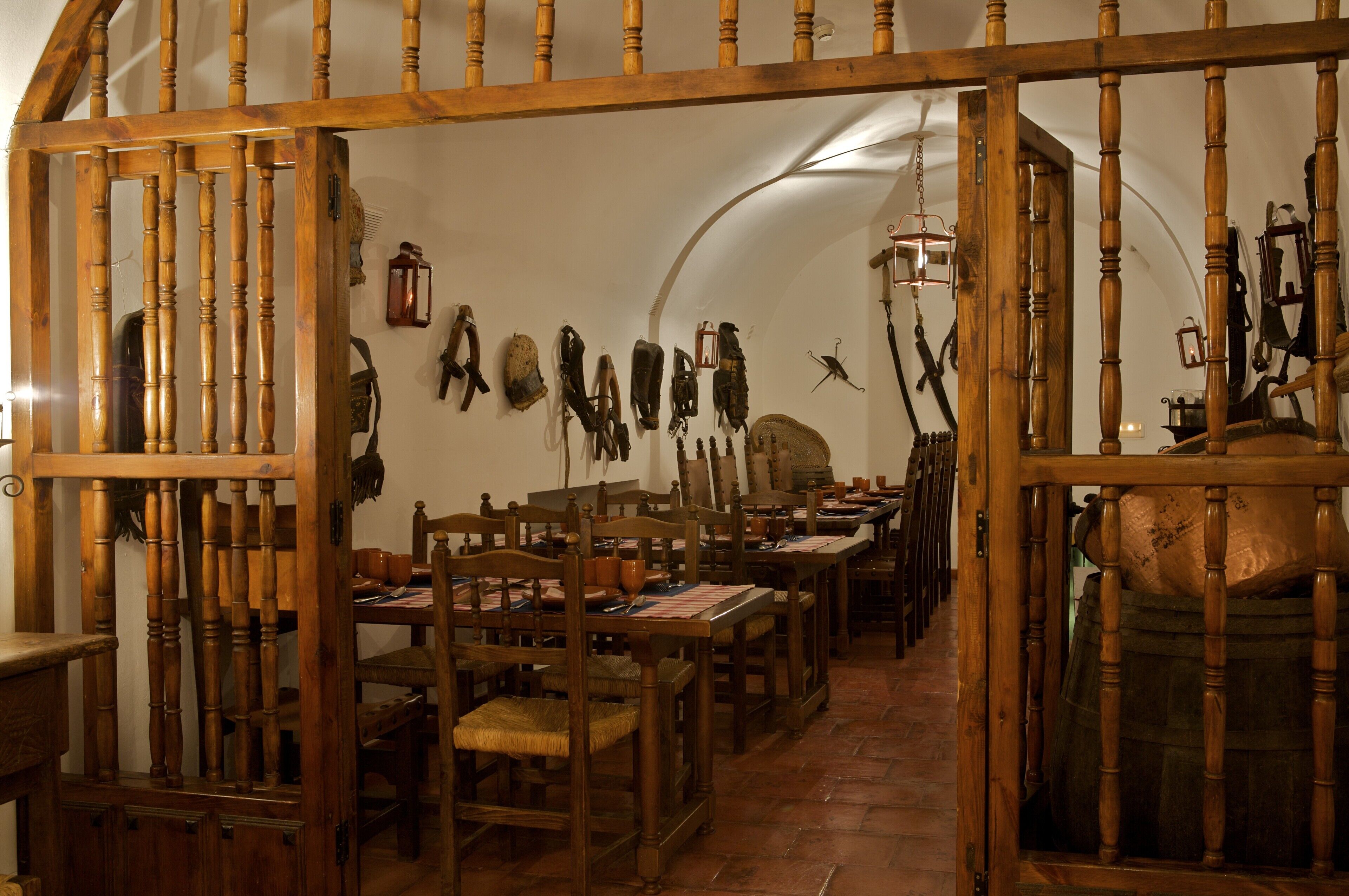 A room with wooden furniture, including tables and chairs, and a variety of items hanging on the walls.