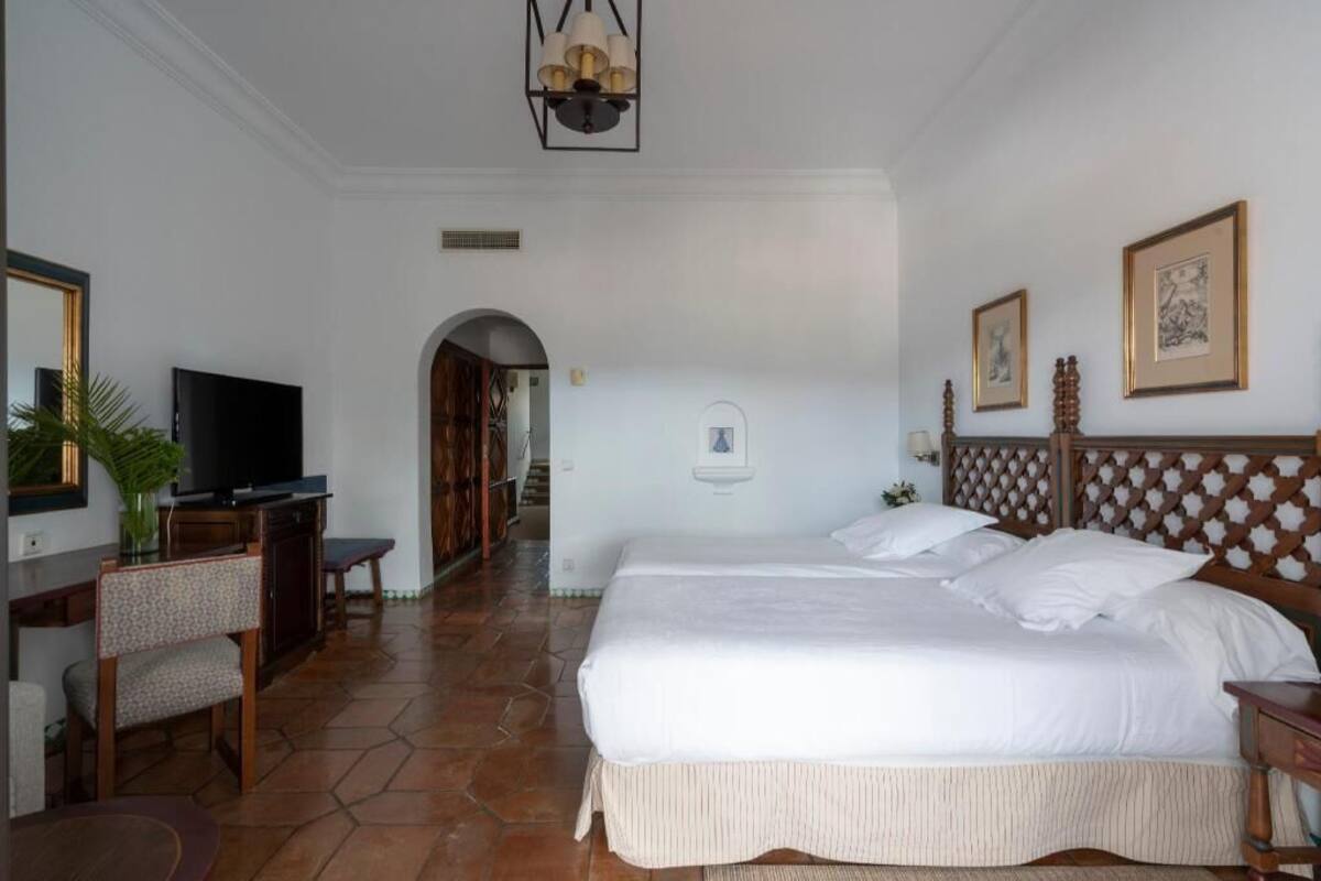 Une chambre d’hôtel avec un grand lit, une télévision, un bureau et une chaise.