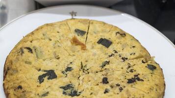 A round, baked dish with visible herbs on a white plate.