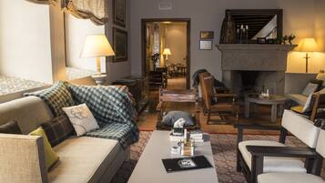 Una sala de estar con sofá, sillones, una mesa de centro y chimenea.