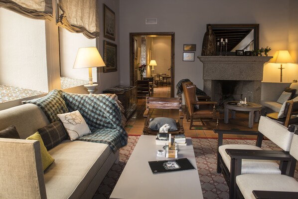 A living room with a sofa, armchairs, a coffee table, and a fireplace. - Parador De Avila (Ávila)