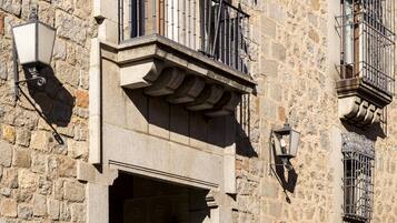 A stone building with a balcony, flags, and a Coca-Cola sign.