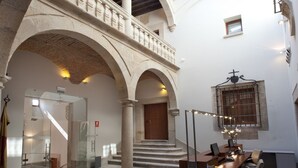A spacious atrium with a high ceiling, arched columns, and a skylight.