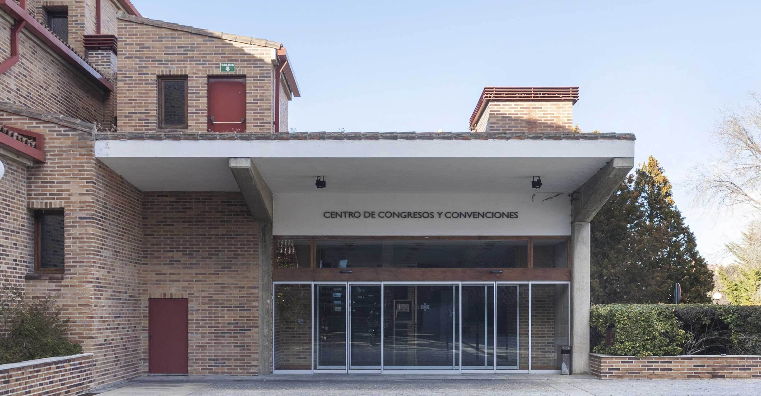 Un edificio con un letrero que dice "CENTRO DE CONGRESOS Y CONVENCIIONES" y una entrada de vidrio.