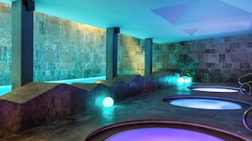 A spa area with stone walls, a seating area, and a water feature.