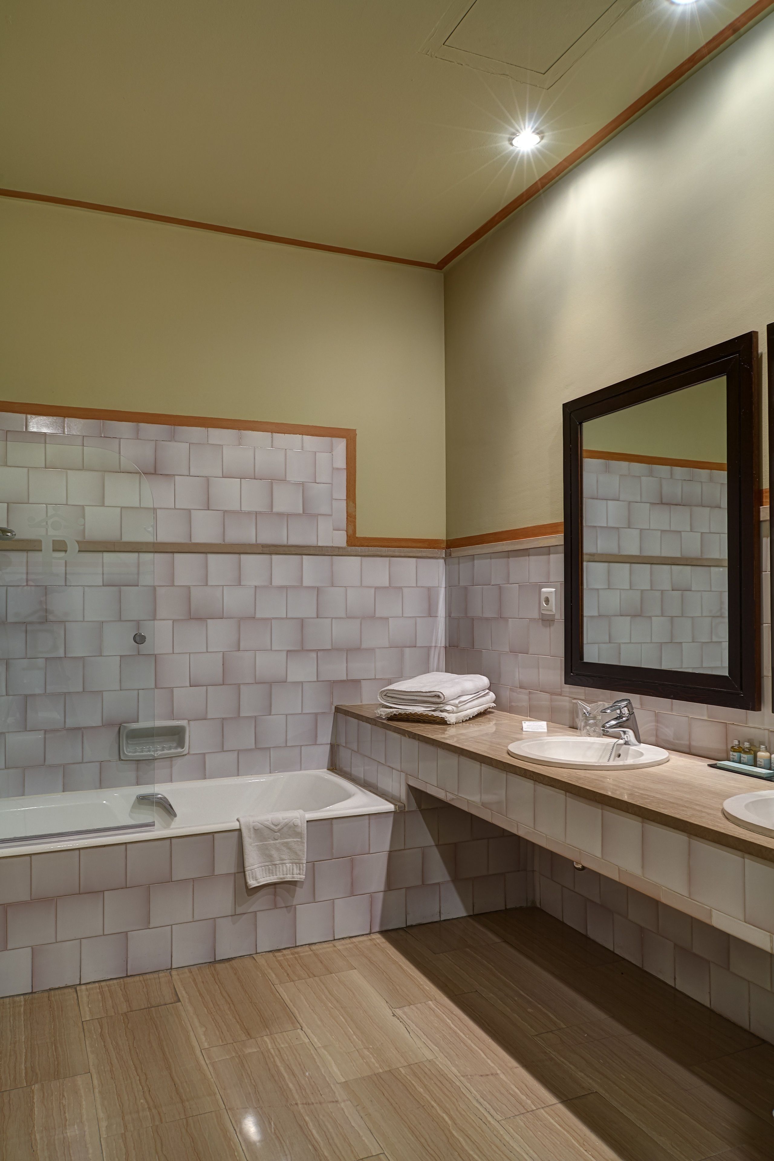 A modern bathroom with a bathtub, a sink, and a large mirror.