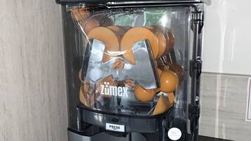 Una cafetera con un depósito transparente para cápsulas de café, una pantalla digital y un panel de control.