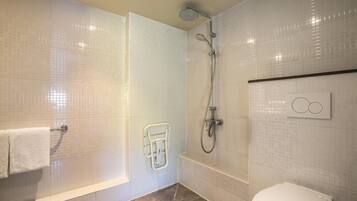 A modern bathroom with a walk-in shower, a toilet, and a towel rack.