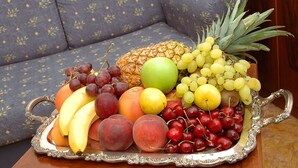 A fruit tray on a table with a patterned sofa in the background. - Cà dei Leoni (Venice)