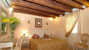 A bedroom with a bed, a desk, a chair, and a mirror. - Cà dei Leoni (Venice)