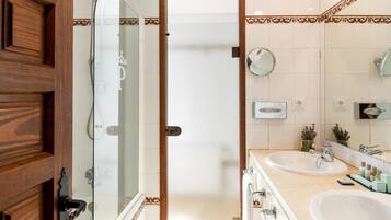 Un bagno con due lavandini, una doccia e uno specchio.