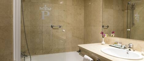 A modern bathroom with a glass-enclosed shower, a white bathtub, and a vanity with a sink and mirror.