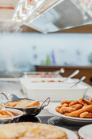 Un buffet proposant divers plats, notamment du pain et des pâtisseries.