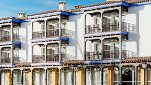 A row of multi-story buildings with balconies and large windows. - Parador de Manzanares (Manzanares)