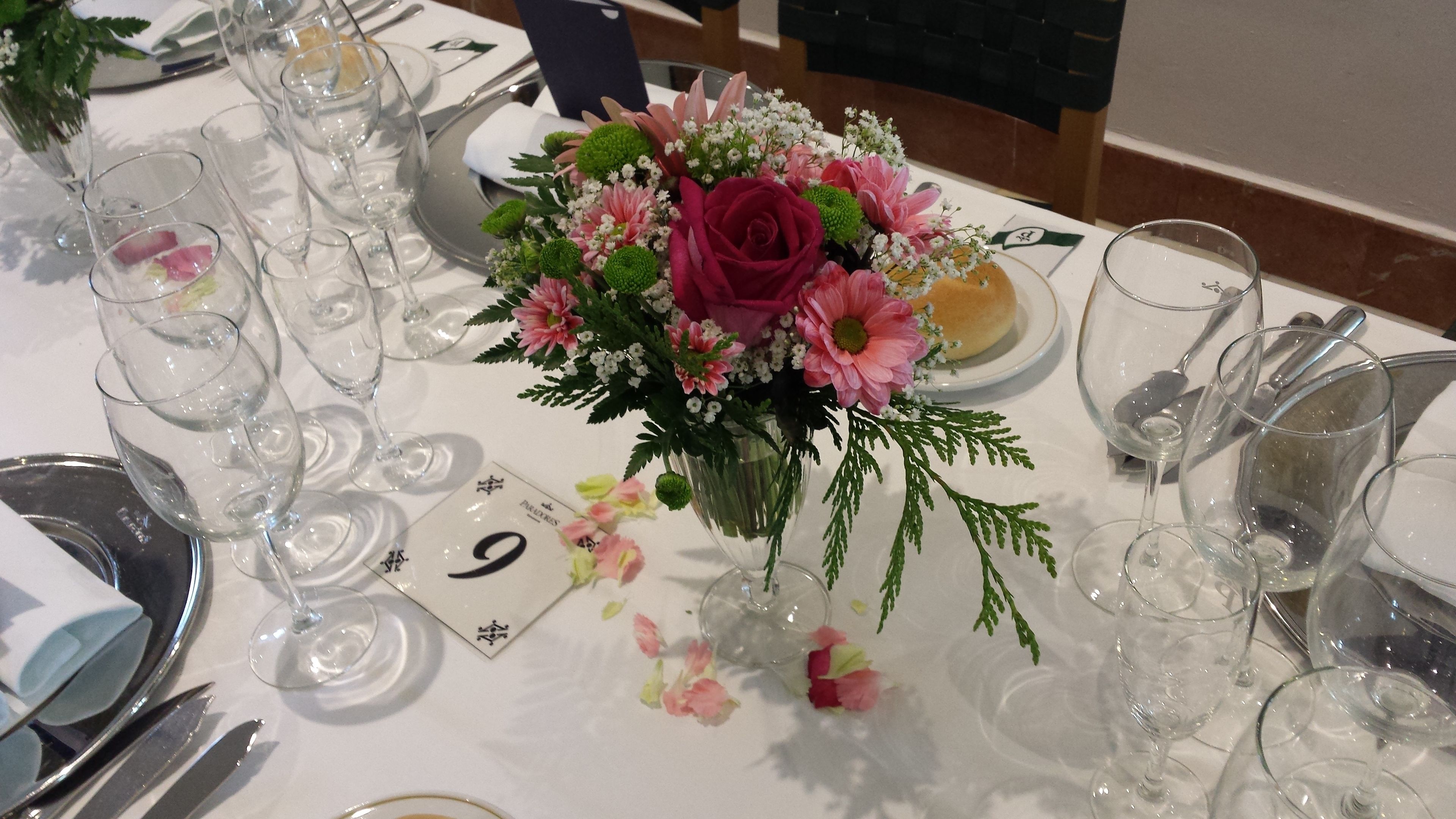 A table set for a formal event with numbered place cards, clear glassware, and a floral centerpiece.