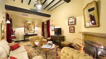 A traditional living room with a fireplace, a television, and classic furniture.