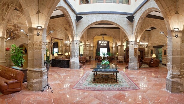 A spacious lobby with high stone arches, leather sofas, and a central table. - Parador de Santo Domingo de la Calzada (Santo Domingo de la Calzada)