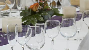 A table set for a formal event with clear glassware, silverware, and a centerpiece of flowers.